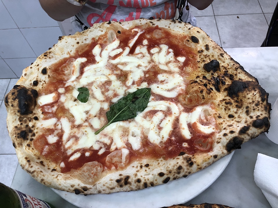 Eating pizza at L'Antica Pizzeria da Michele, one of our 13 amazing things to do in Naples, Italy.