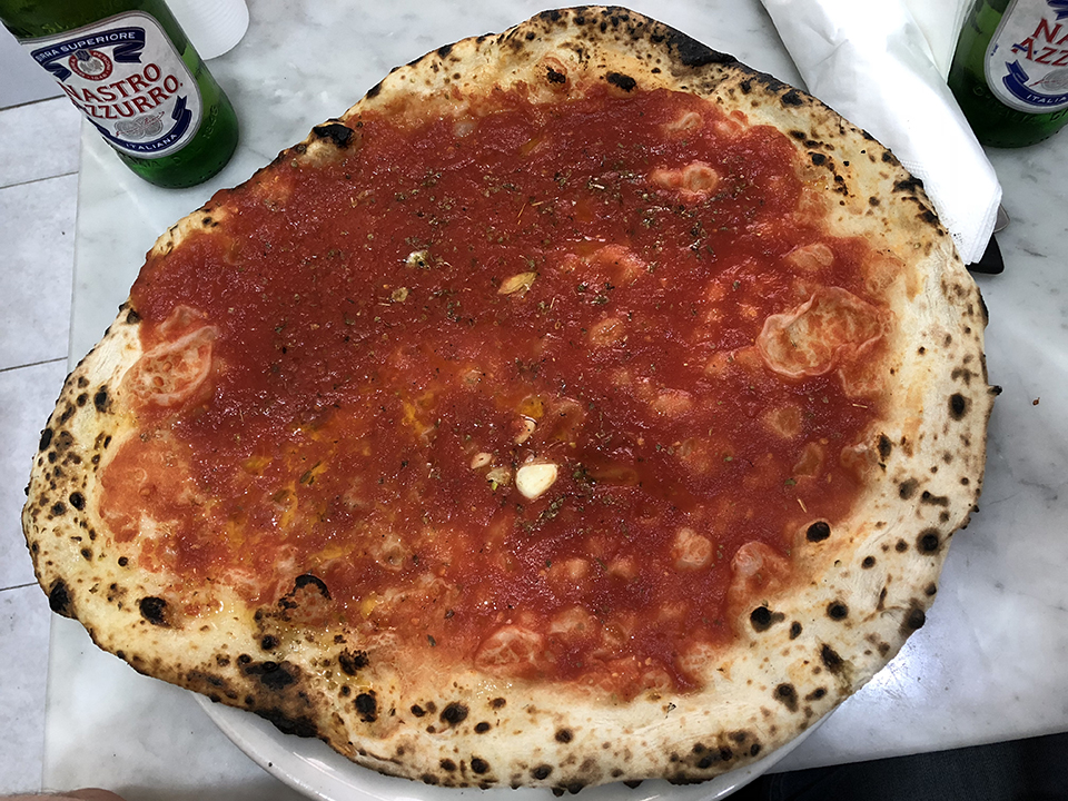 Eating pizza at L'Antica Pizzeria da Michele, one of our 13 amazing things to do in Naples, Italy.