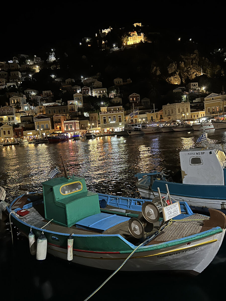 Drinking cocktails down by the harbour, night time in Symi, Greece.