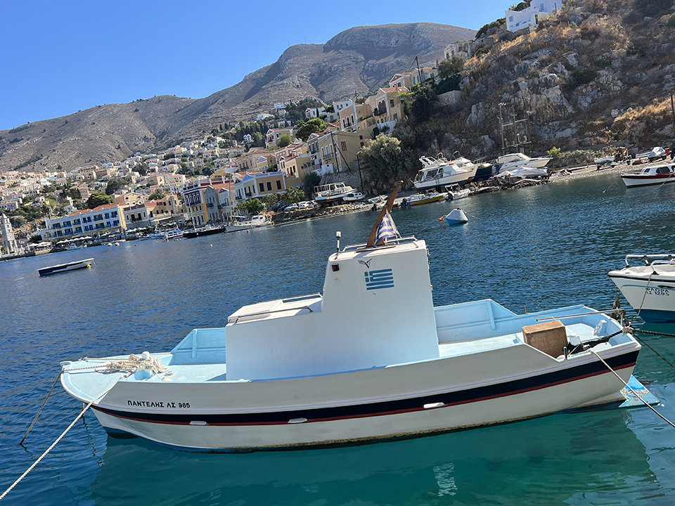 Beautiful Symi harbour, clear blue sea and fishing boats.