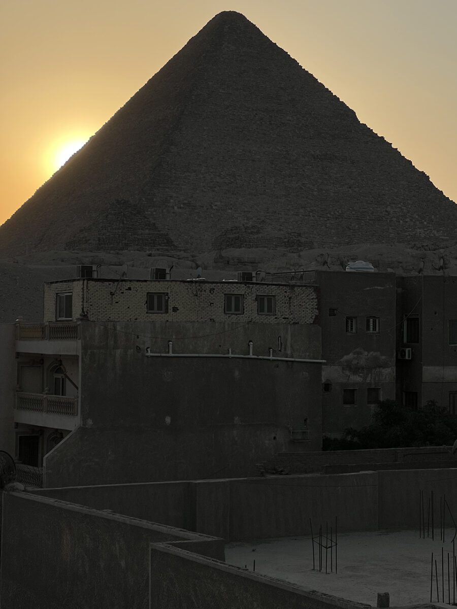 The sun sets behind the Pyramids of Giza, Egypt.